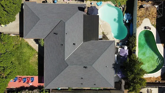 Freshly installed asphalt shingle roof on a modern suburban home in Modesto California with detailed texture, vibrant color, and well-crafted ridge cap