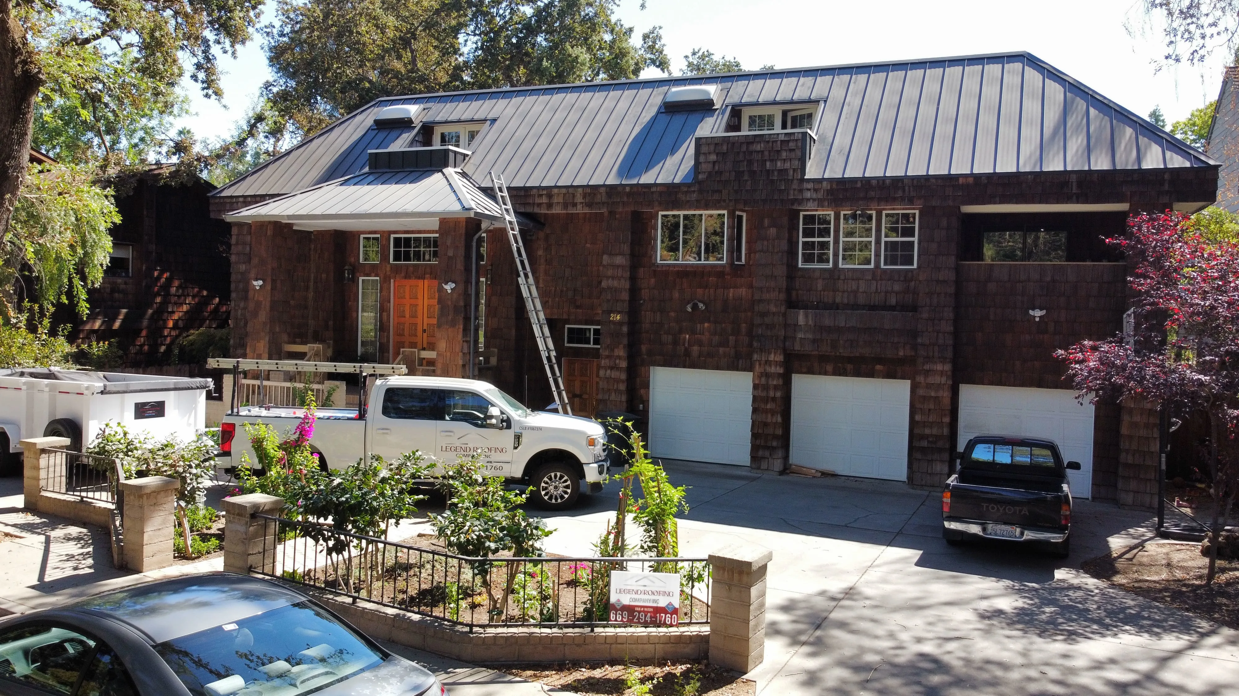Repaired suburban roof in Modesto CA with durable shingles, flashing, lush greenery, clear sky showcasing craftsmanship