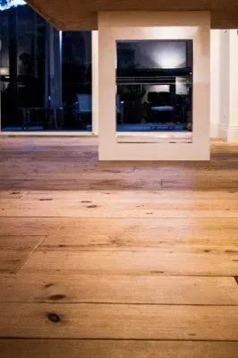 Completed wood flooring installation in North Fort Myers, showcasing polished oak planks in a spacious, elegant living room.