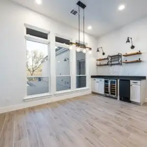 Renovated Austin TX home interior with modern design, large windows, natural light, stylish decor, lush greenery outside