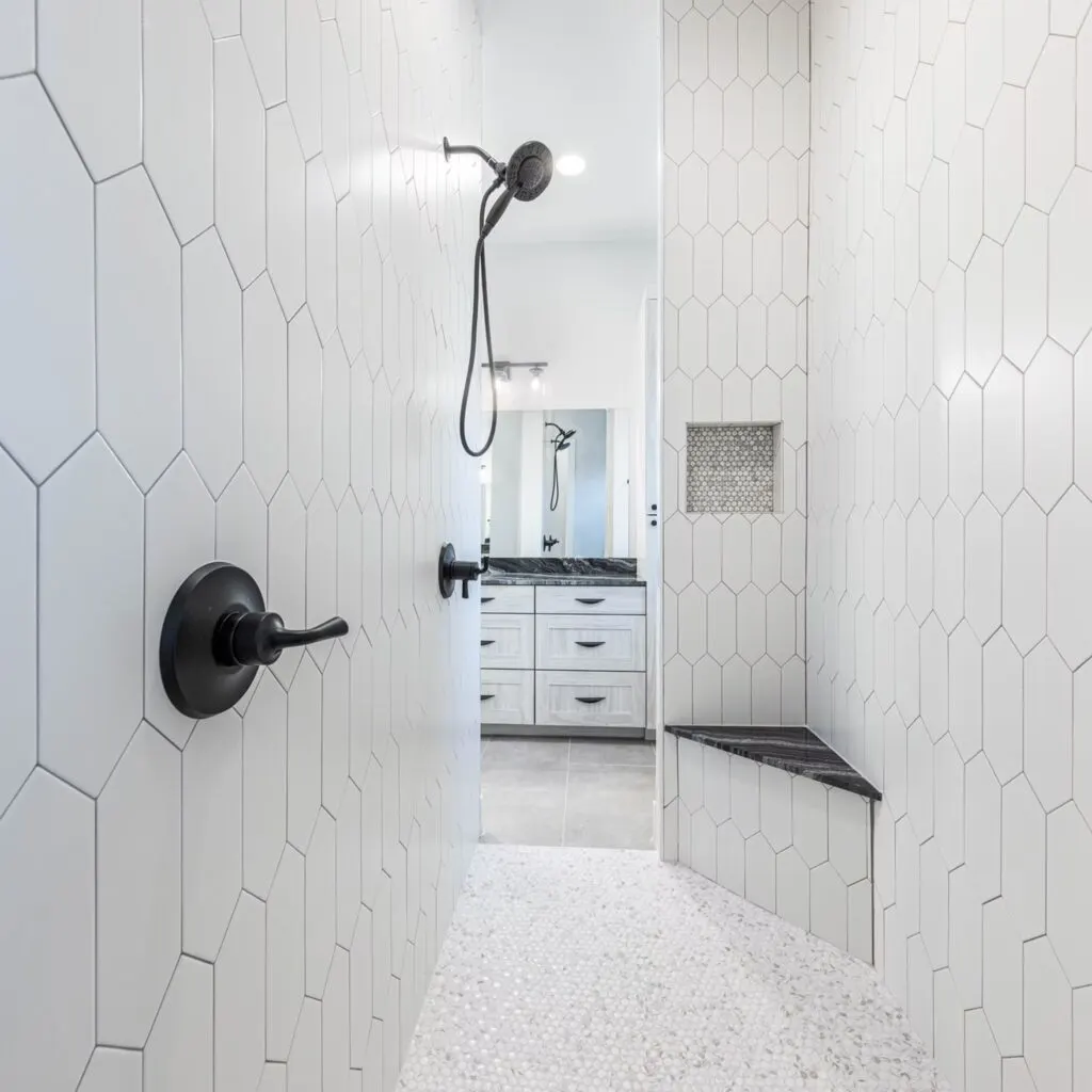 Modern bathroom with frameless glass shower enclosure, sleek tiles, rainfall showerhead, stylish vanity, and polished flooring in Austin