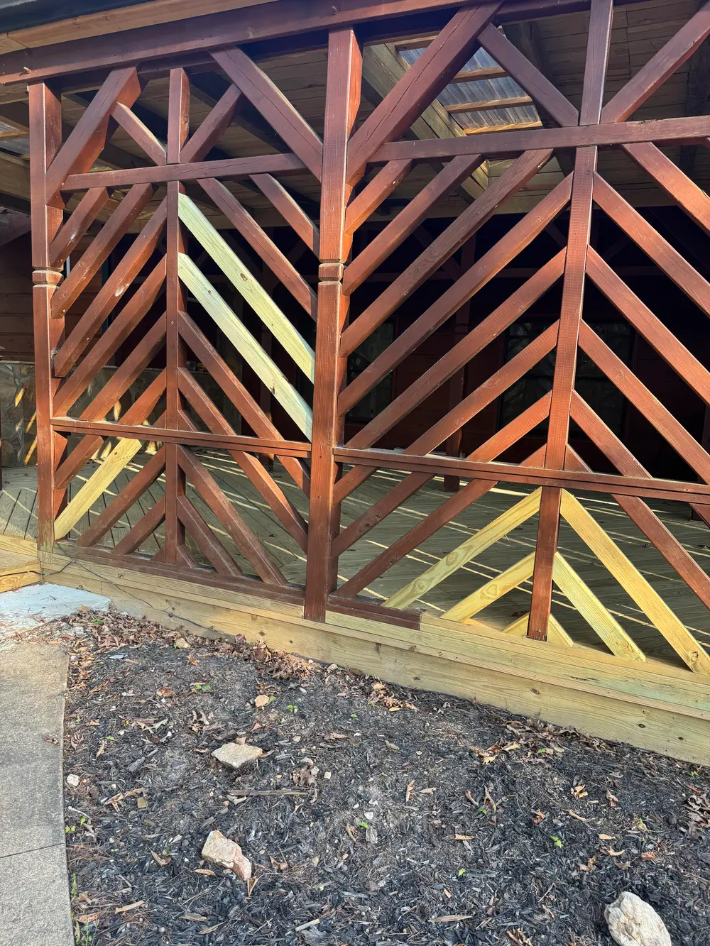 Beautifully crafted wooden gate repair in Cohutta GA with rich wood tones and a well-maintained yard backdrop.