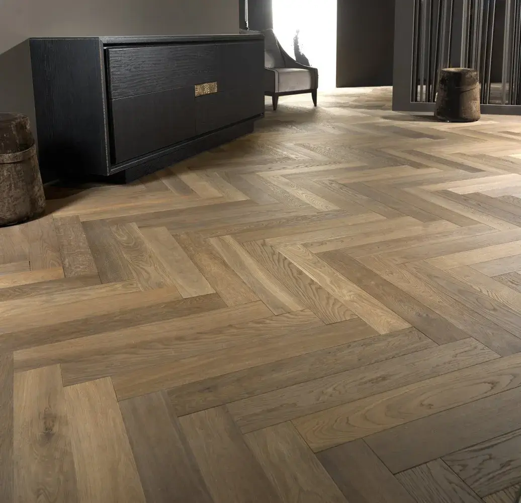 Completed wood flooring installation in Isles Of Capri FL featuring rich oak planks in herringbone pattern with natural light.