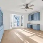 Stylish converted Austin garage with hardwood floors, modern furniture, natural light, potted plants, and Texas skyline view