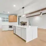 Modern Austin kitchen with polished quartz countertop, minimalist cabinetry, stainless steel appliances, and natural sunlight.