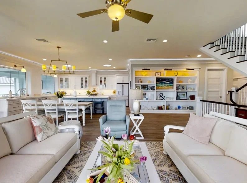 Spacious coastal living room in Ponce Inlet, FL with soft colors, polished hardwood, and beach-themed decor.