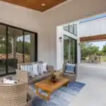 Modern Austin garage conversion with sleek drywall, large windows, hardwood floors, contemporary furniture, and lush greenery background