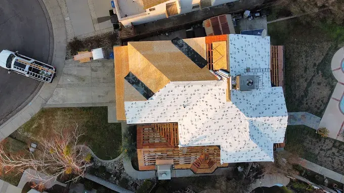 New asphalt shingle roof on a suburban home in Modesto California with lush yard and neighborhood background