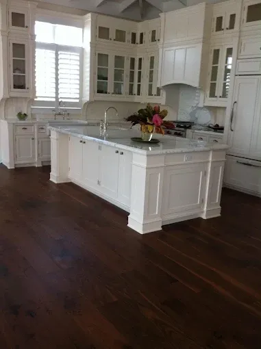 Wood flooring installation in an upscale living room with polished hardwood, natural light, and elegant decor.