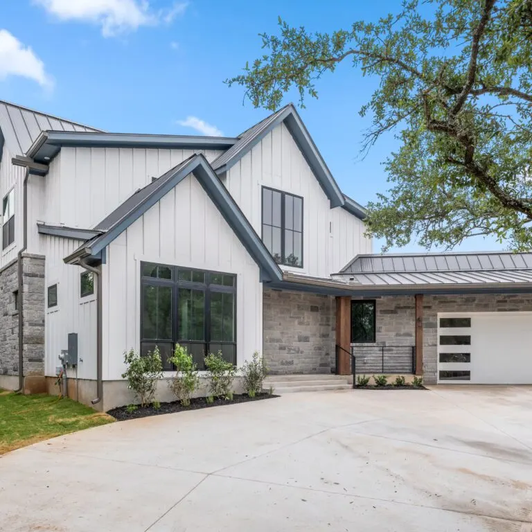 Newly expanded modern home in Austin Texas with large energy-efficient windows, landscaped yard, and sunset outdoor living space