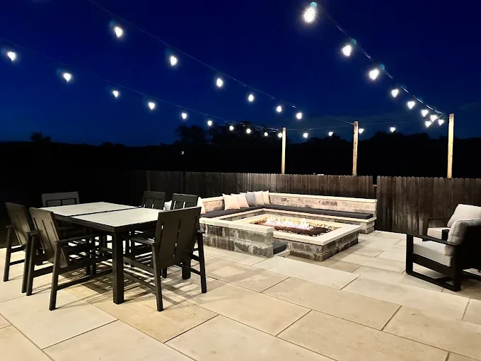 Newly built modern ADU in Austin Texas with warm tones, large windows, lush lawn, native plants, and scenic backdrop