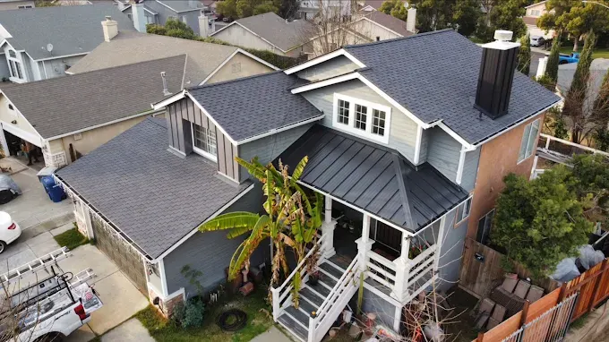 Modern commercial building in Modesto with sleek metal roof, stucco exterior, glass windows, landscaped gardens, sunny day