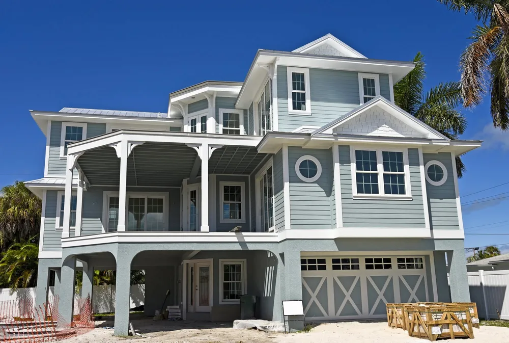Vibrant coastal home trim spraying in New Smyrna Beach with crisp white paint and tropical landscaping under blue skies.