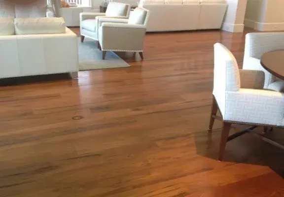 Gleaming hardwood floors in a modern Naples home with elegant decor and natural sunlight create a clean, inviting atmosphere.