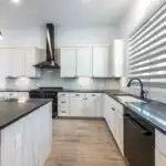 Modern Austin kitchen with matte gray cabinets stainless steel appliances quartz countertops hardwood floors and large windows