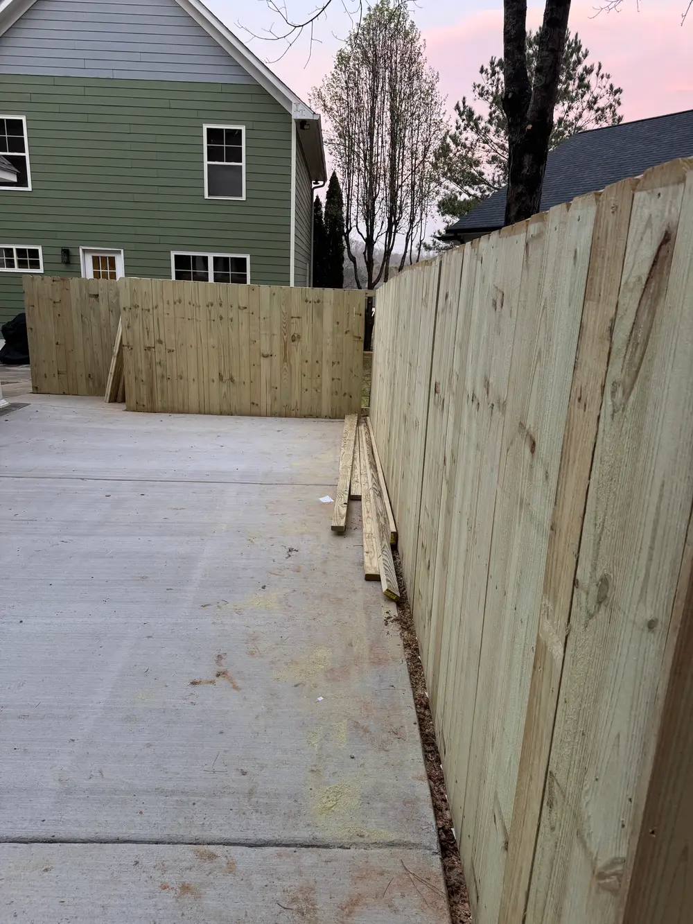 Completed wooden fencing installation in Resaca GA, showcasing craftsmanship and harmony with a manicured lawn.