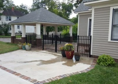 Sturdy wooden fence installation in Knoxville TN beside lush lawn with flowers and trees under a blue sky.