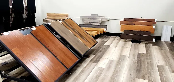 Showroom in Oklahoma City displaying diverse hardwood, laminate, and tile flooring with elegant design and warm ambiance.