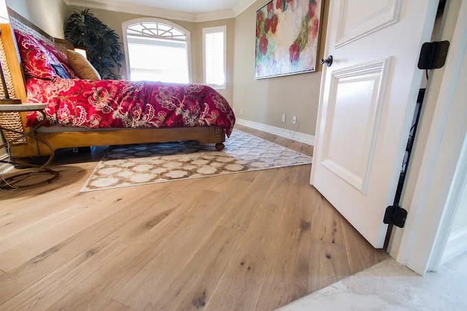Elegant wooden flooring in herringbone pattern with warm tones, complemented by neutral walls and natural light.