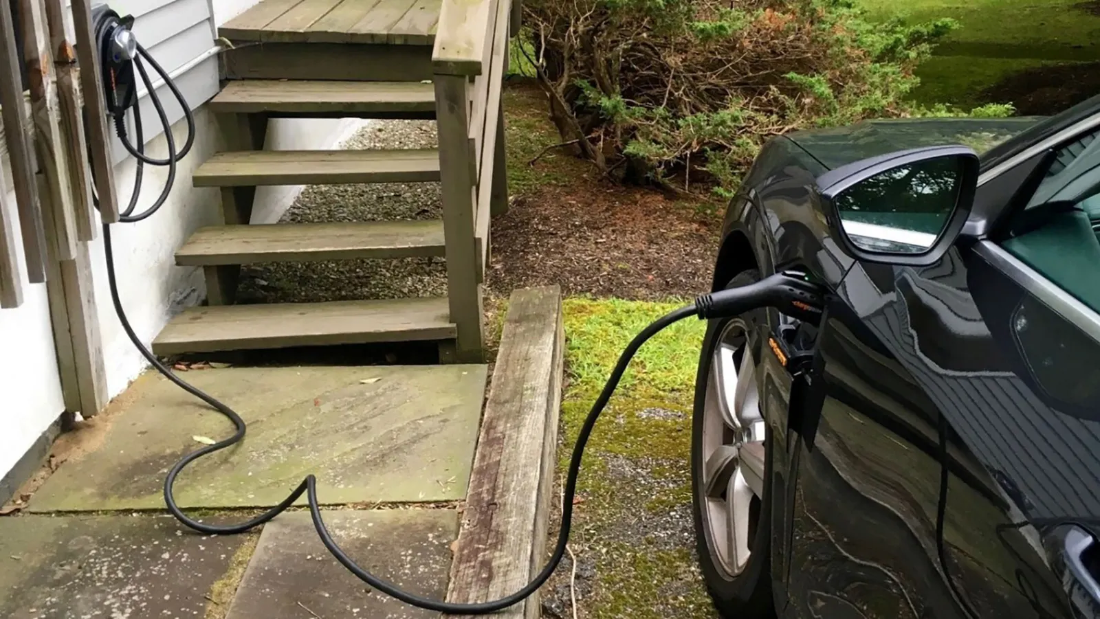 Electric vehicle charger mounted on a concrete pad with organized wiring in a commercial modern setting