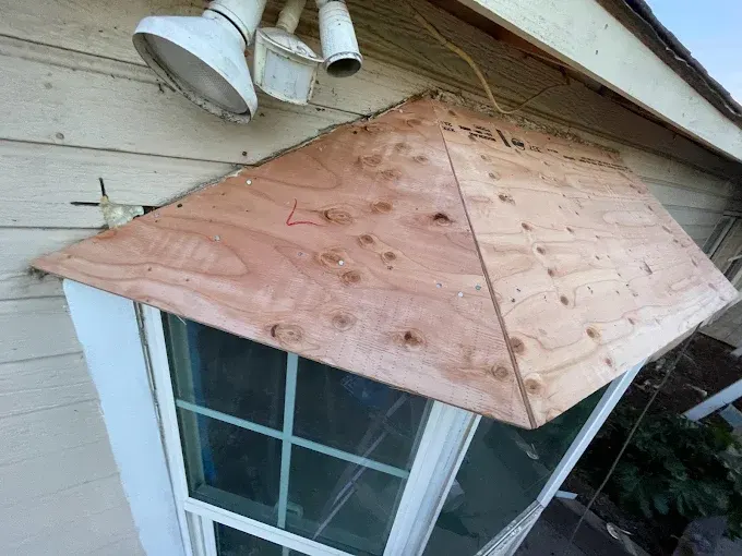 Freshly repaired roof flashing on a residential home in Modesto California with clean metal installation and lush greenery