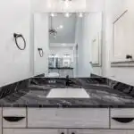 Renovated kitchen in Holly TX with modern appliances, spacious island, natural light, and cozy living area ambiance.