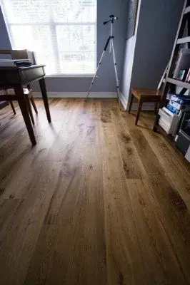 Elegant hardwood floor sealing in Naples FL, showcasing rich grain patterns and polished surface in a stylish room.