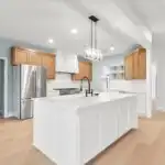 Modern Austin kitchen with matte black cabinets stainless steel appliances quartz countertops large island neutral backsplash natural light stylish open-concept bright and elegant