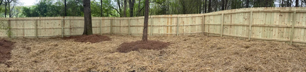 Completed wooden fence installation in Resaca GA, showcasing craftsmanship in a serene rural landscape.