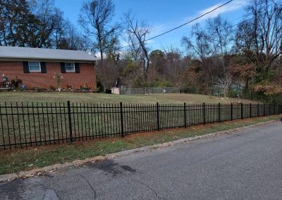 Completed wood fence installation in Knoxville TN, showcasing expert craftsmanship, natural finish, and vibrant landscaping.