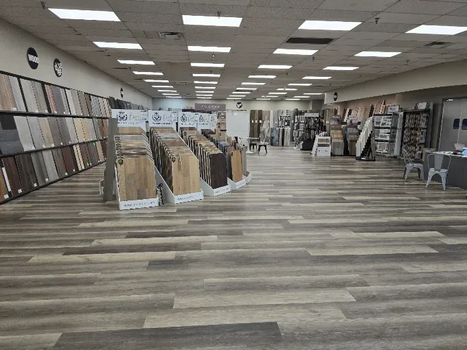 Showroom displaying various high-quality flooring options like hardwood, tile, and carpet in an elegant setting.