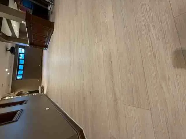 Solid hardwood floors gleam under ambient light in a sophisticated Darien IL living space with elegant decor.