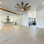Modern kitchen and living area in South Lamar TX featuring walnut cabinetry, quartz countertops, and natural light.