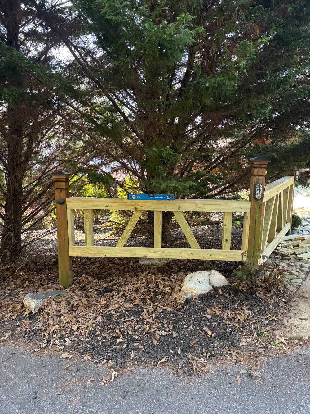 Completed wooden privacy fence installation in Cohutta GA surrounded by green grass and blooming flowers.