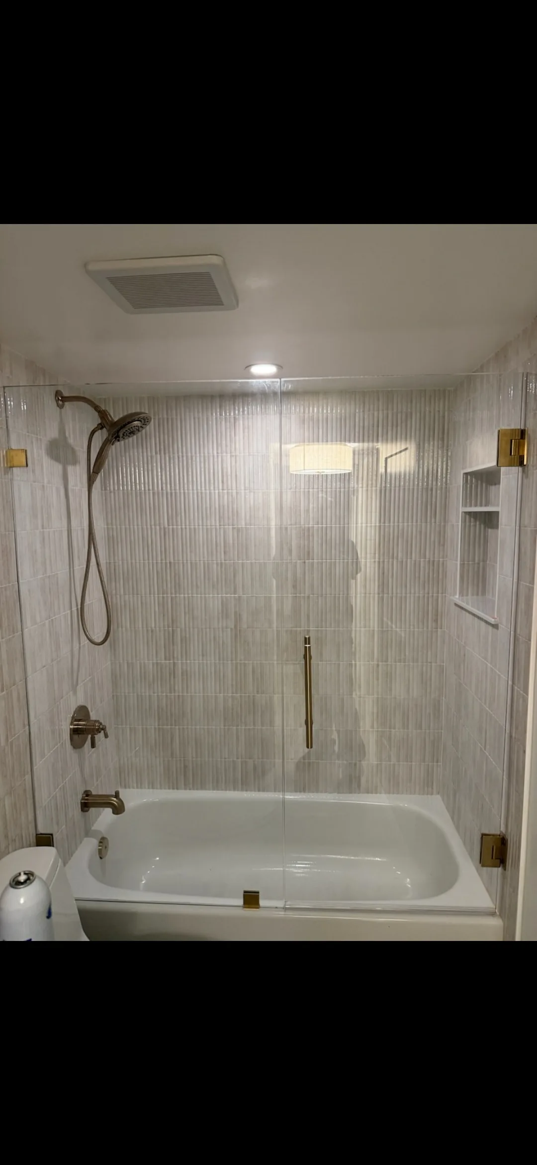 Modern bathroom with frameless glass shower, freestanding tub, marble countertops, neutral tones, and natural light.