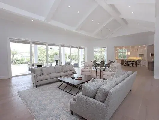 Polished wood flooring installed in a stylish Naples living room with natural light and elegant decor.