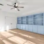 Modern Austin room addition with large windows hardwood floors lush backyard Texas plants neighborhood scene
