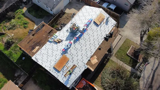 Freshly repaired suburban home roof in Modesto with detailed shingles, bright daylight, and a clean, well-maintained neighborhood