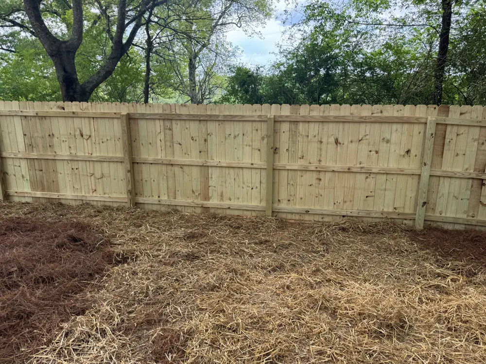 Beautiful wooden fence installation in Chatsworth GA, showcasing rich brown wood and detailed craftsmanship in a lush landscape.
