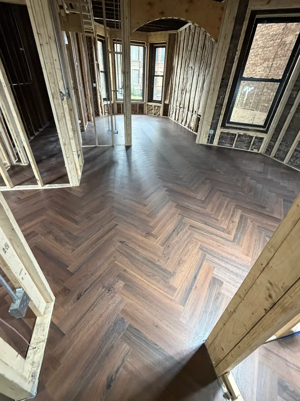 Engineered hardwood installation in a sunlit Darien IL living room with warm tones, modern furniture, and elegant decor.