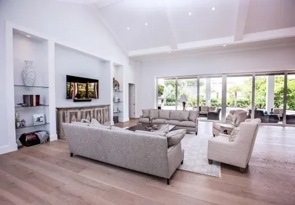 Polished hardwood flooring in a spacious, well-lit Naples room, showcasing rich wood tones and craftsmanship.