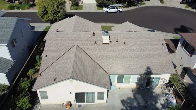 Close-up of a new soffit vent installation on a modern home in Modesto, CA, with clean fascia and lush neighborhood background
