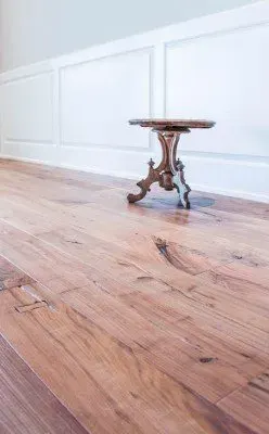 Beautifully polished hardwood flooring in herringbone pattern with modern decor in Tice, FL, showcasing elegance and warmth.