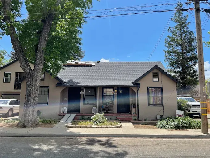 Repaired storm-damaged roof in Modesto with precise shingles, secure flashing, and durable materials in a sunny suburban neighborhood
