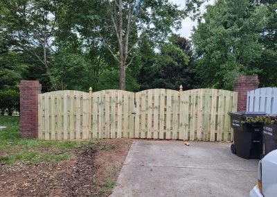 Completed cedar wood fence in a manicured backyard in Knoxville TN with vibrant grass and colorful flowers.