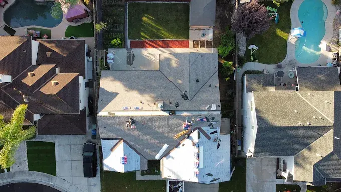 Repaired storm-damaged roof with uniform shingles on suburban home in Modesto California showing quality craftsmanship and reliable repair