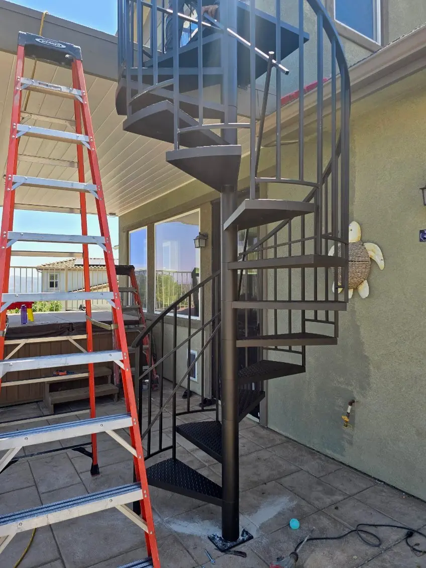 Custom wrought iron gate installation in Los Angeles framed by lush landscaping and rolling hills.