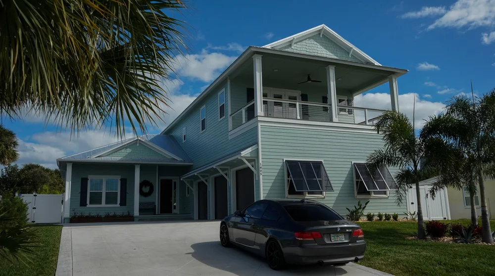 New construction painting of a modern home in New Smyrna Beach with vibrant colors and lush landscaping.