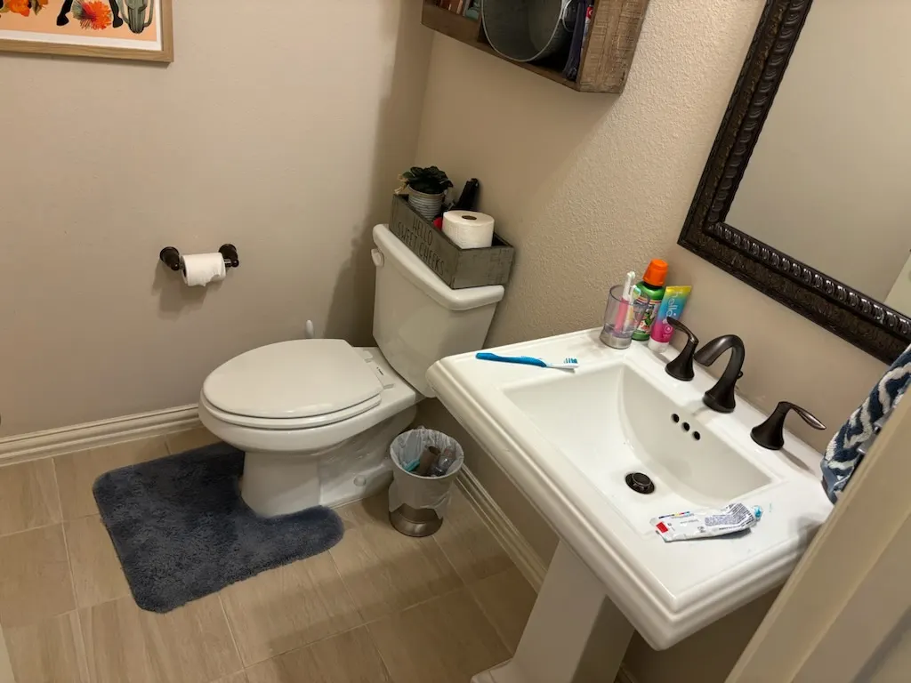 Beautyfully designed bathroom vanity with wooden cabinet, marble top, modern fixtures, large mirror, natural light, elegant tiles, and decor