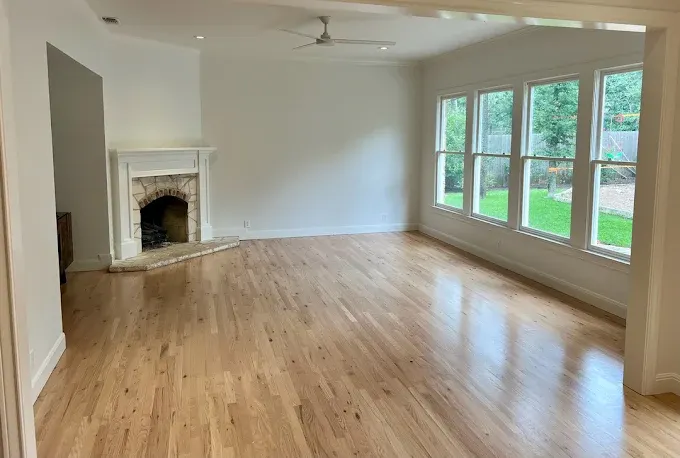 Modern kitchen remodel in West Lake Hills TX features white cabinetry, marble island, stainless steel appliances, and natural light.